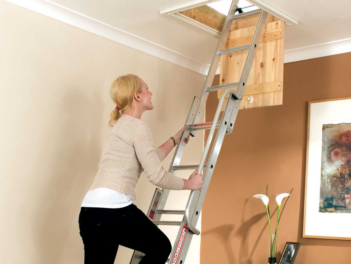 Woman climbing up an attic ladder